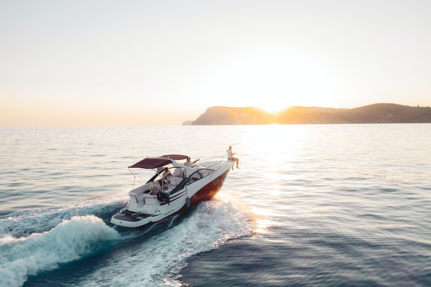 A Yacht Speeding Towards A Sunset