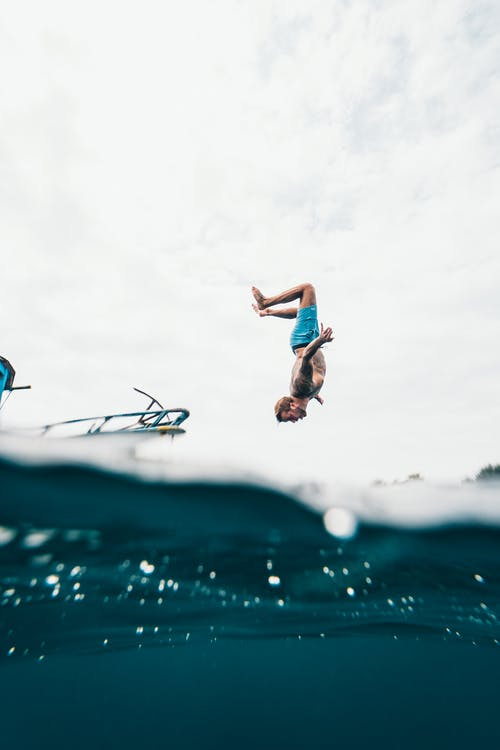 man jumping off a yacht